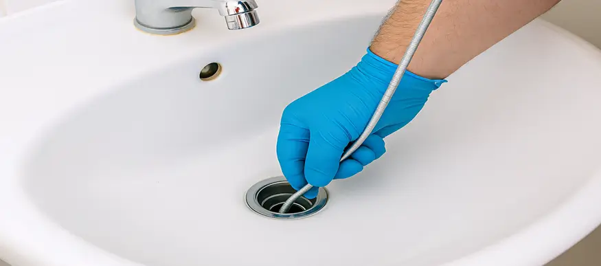 Plumber Cleaning a Clogged Drain in Pearland